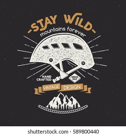 Vintage mountaineering badge. Climbing logo, vintage vector emblem. Climb gear - helmet and text "Stay wild - mountains forever". Retro t shirt rough design.