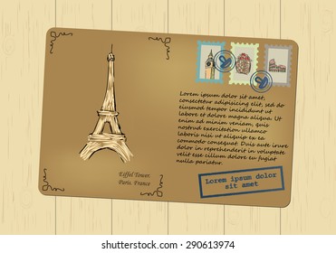 Vintage postcard with the Eiffel Tower. Stamps with sights. Printing with place for your text. Wooden background. Vector graphics.