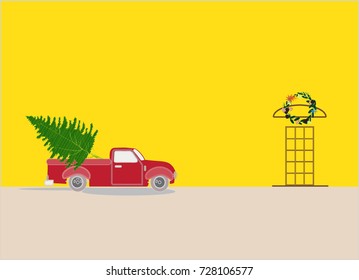 Vintage red truck pickup Christmas tree. Parking near by yellow house that hanging Christmas wreath above the door.