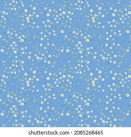 Vintage seamless floral pattern. Ditsy style background of small white and yellow flowers. Small blooming flowers scattered over a blue background. Stock vector for printing on surfaces design.