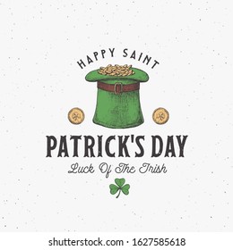 Vintage Style Saint Patricks Day Logo or Label Template. Hand Drawn Leprechauns Hat Full of Gold Coins and Shamrock Leaf Sketch Symbols with Retro Typography. Shabby Texture Background. Isolated.