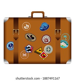 Vintage suitcase from the front, decorated with various stickers, souvenirs from tourist trips.