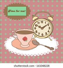 Vintage tea mug, saucer,spoon and alarm clock on tablecloth