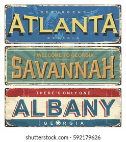 Vintage tin sign collection with US cities. Atlanta. Savannah. Albany. Retro souvenirs or old postcard templates on rust background.
