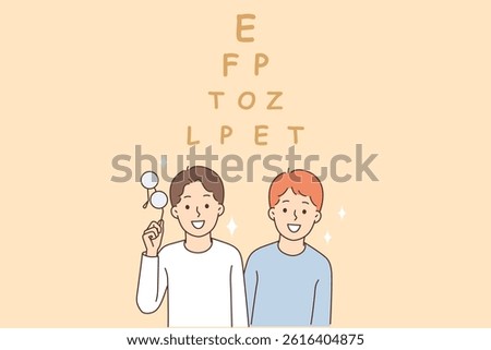 Vision test for children standing near pyramid of letters and smiling at screen. Vision testing of little boys holding glasses recommended by doctor to get rid of eye diseases and treat myopia