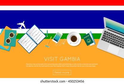 Visit Gambia concept for your web banner or print materials. Top view of a laptop, sunglasses and coffee cup on Gambia national flag. Flat style travel planninng website header.