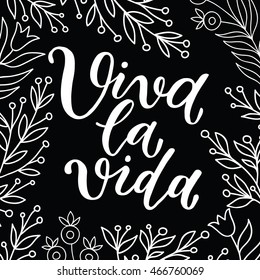 "viva la vida" hurray for life ink lettering poster with floral branches on a black background. Calligraphy poster, postcard, print.