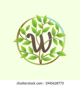 W letter logo made of twisted tree branches and green leaves in circle. Ecology vector font for vegan emblem, botanical identity, creative spring t-shirts, organic merchandise.