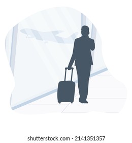 Esperen al avión. Silhouette de un hombre hablando por teléfono, empresario mirando a través de la ventana en el aeropuerto, hablando por teléfono en el aeropuerto 