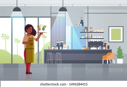 waitress holding serving tray with cocktails african american woman restaurant worker in uniform carrying different alcohol drinks modern cafe interior flat full length horizontal