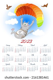 Wall calendar 2023 with a cartoon cat enjoying paragliding on a colorful parachute. 12 months on one sheet