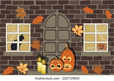 The wall of the house with windows and door, on the threshold of Halloween are pumpkins and candles