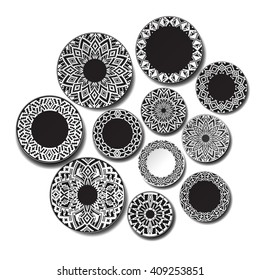 Wall with plates. The background plates on the wall. Isolated dish. Black plate with ethnic ornament in the African style on a white background