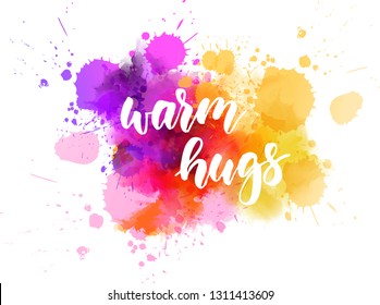 Warm hugs - handwritten modern calligraphy lettering text on multicolored watercolor paint splash.