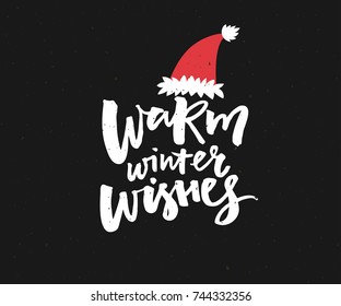 Warm winter wishes. Christmas card design with brush lettering in red Santa hat