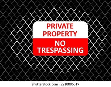 Warning sign on a chain link fence with the light aimed at it.