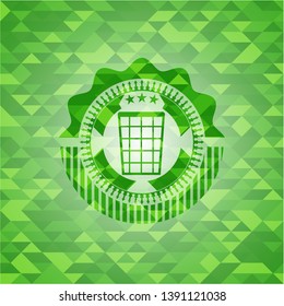 wastepaper basket icon inside green emblem with triangle mosaic background