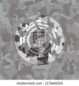 wastepaper basket icon inside grey camouflaged emblem