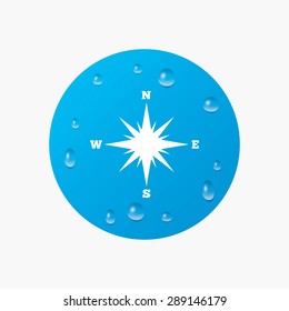 Water drops on button. Compass sign icon. Windrose navigation symbol. Realistic pure raindrops. Blue circle. Vector