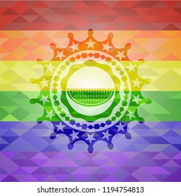 watermelon icon inside emblem on mosaic background with the colors of the LGBT flag