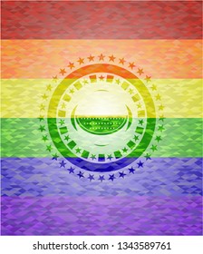 watermelon icon inside emblem on mosaic background with the colors of the LGBT flag