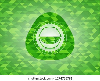 watermelon icon inside green emblem with triangle mosaic background