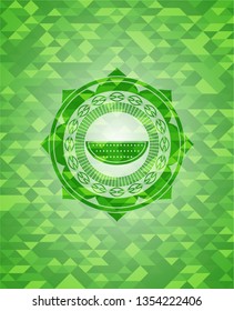 watermelon icon inside green emblem with triangle mosaic background