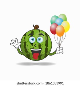 Watermelon mascot character holding a balloon. vector illustration