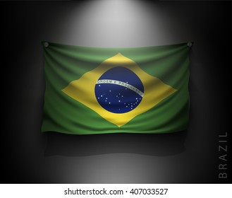 waving flag brazil on a dark wall with a spotlight, illuminated