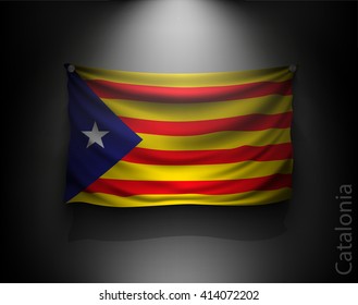 waving flag catalonia on a dark wall with a spotlight, illuminated