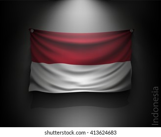 waving flag indonesia on a dark wall with a spotlight, illuminated