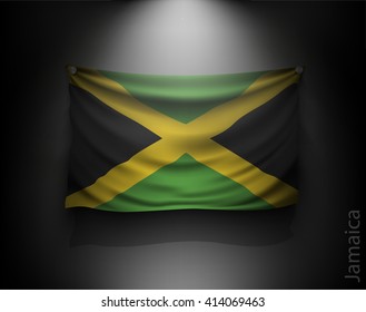 waving flag jamaica on a dark wall with a spotlight, illuminated