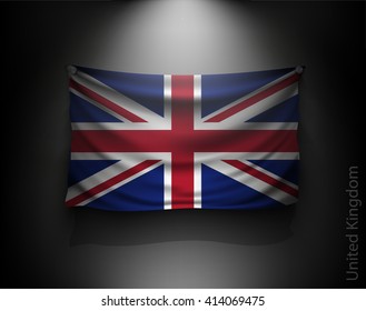 waving flag United Kingdom on a dark wall with a spotlight, illuminated