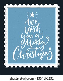 We wish you a Merry Christmas lettering. Calligraphy text on blue vintage stamp background, winter holidays greeting card