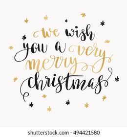 We wish you a very merry Christmas. Christmas greeting card with calligraphy. Handwritten modern brush lettering. Black and gold quote on white background