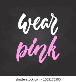 Wear pink - hand drawn October Breast Cancer Awareness Month lettering phrase on black chalkboard background. Brush ink vector quote for banners, greeting card, poster design