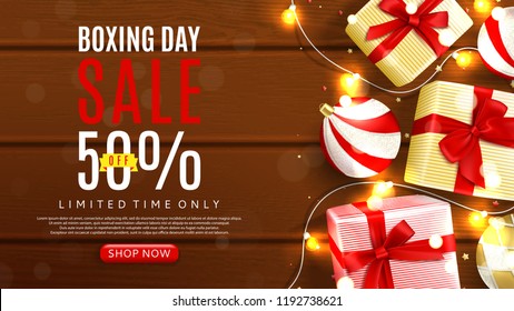 Web banner template for Boxing day sale. Top view on realistic gift boxes and Christmas balls on rustic wooden texture. Vector illustration with confetti and effect bokeh.