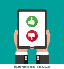 Website rating feedback and review concept. Hand holding and pointing to a tablet with thumb up and down and down  sign button on the screen.