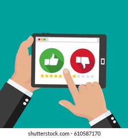 Website rating feedback and review concept. Hand holding and pointing to a tablet with like and dislike and star rate