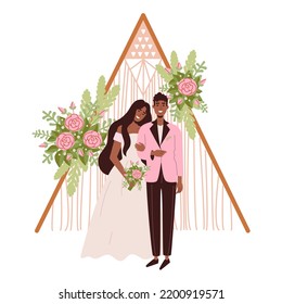 Wedding arch in Hippie and Boho style. Beautiful dark-skinned bride and groom. A woman in a wedding dress with a bouquet