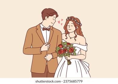 Wedding ceremony at bride and groom in beautiful outfits holding hands during engagement in church. Woman with bouquet flowers stands near husband at wedding ceremony, posing together for family photo