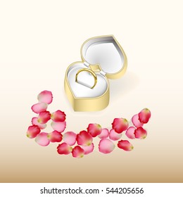 Wedding ring in a golden box and rose petals. Valentine's Day.