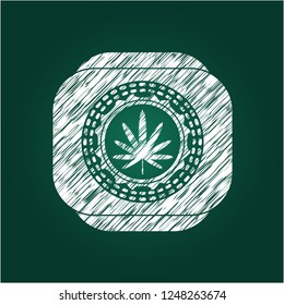weed leaf icon inside chalk emblem written on a blackboard