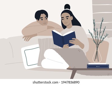 Weekend leisure activities, an Asian couple reading a book together in the living room, cozy domestic life during the lockdown