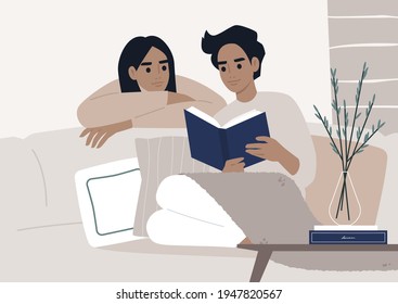 Weekend leisure activities, a couple reading a book together in the living room, cozy domestic life during the lockdown