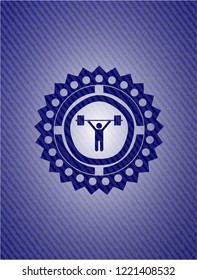 weightlifting icon inside badge with denim texture
