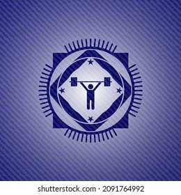 icono de levantamiento de pesas dentro del emblema con fondo de jean. 