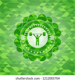 weightlifting icon inside green emblem with triangle mosaic background