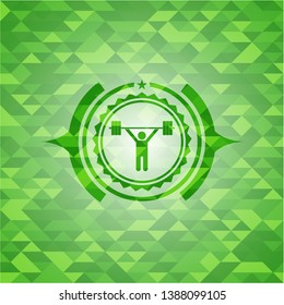 weightlifting icon inside green emblem with triangle mosaic background