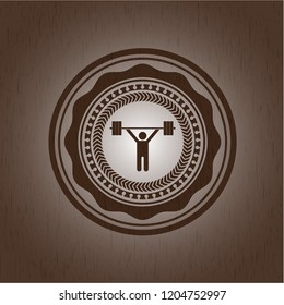 weightlifting icon inside wood badge or emblem